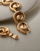 chunky statement gold bracelet with swirl details