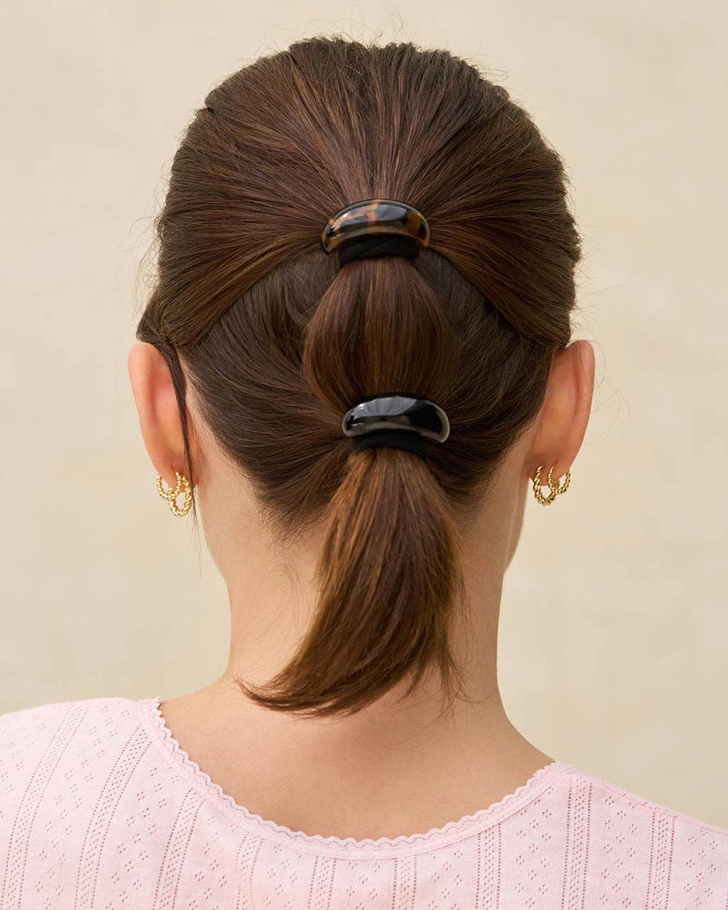 Back view of a person with brown hair tied in a ponytail using a Black and tortoiseshell cloud-shaped hair cuffs
