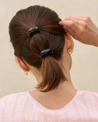 Back view of a person with brown hair tied in a ponytail using a Black and tortoiseshell cloud-shaped hair cuffs