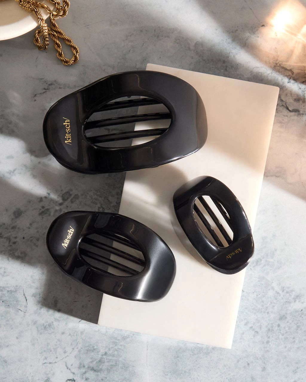 three black hair clip with 'kitsch' branding