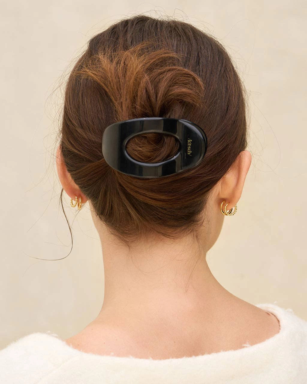 woman wearing black hair clip with 'kitsch' branding