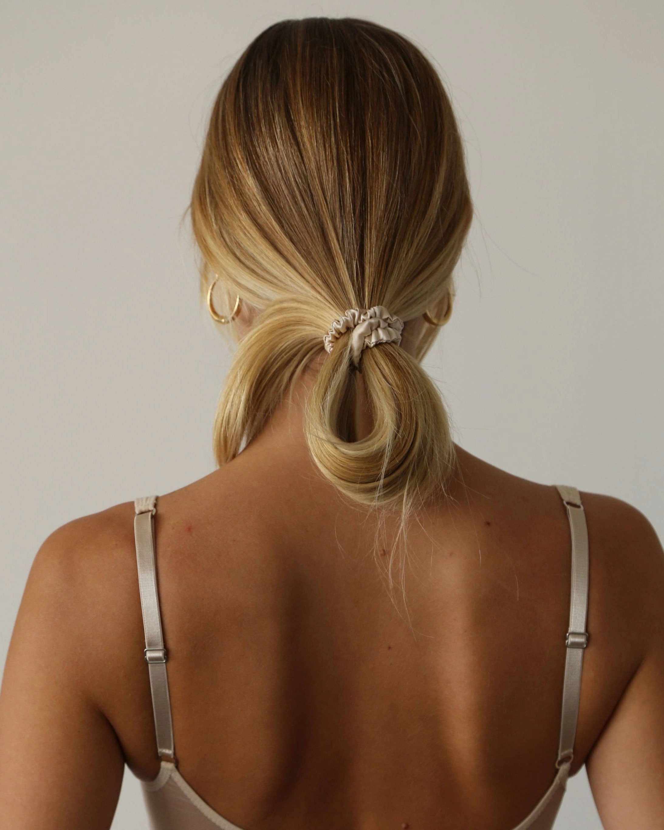 view of a person with champagne silk scrunchie ponytail