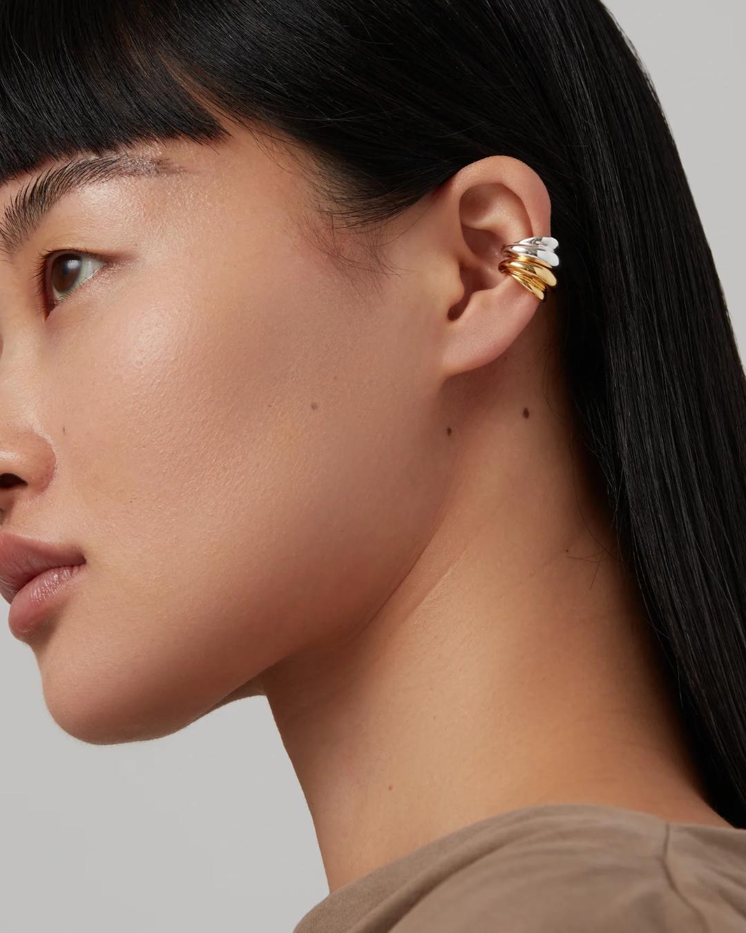 two ear cuffs one in silver and the other in gold