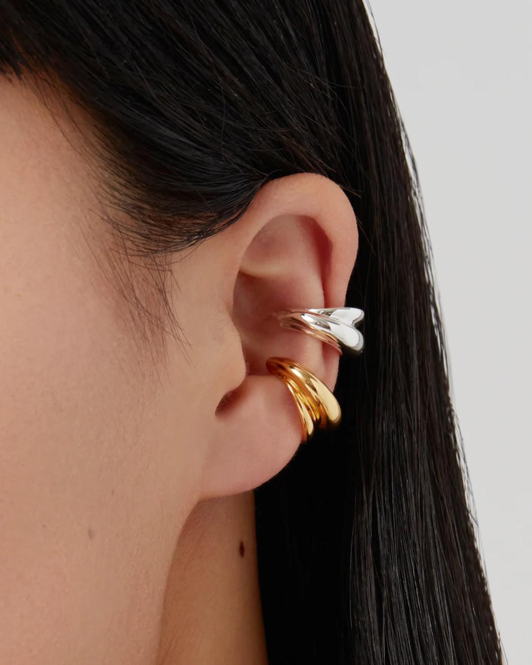 two ear cuffs one in silver and the other in gold