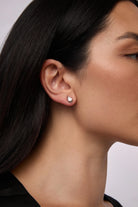 a woman wears a teardrop shaped crystal earring with silver by brand Lili Claspe