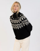 Woman wearing a fairisle sweater in blavk with cream accents