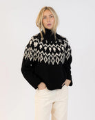 Woman wearing a fairisle sweater in blavk with cream accents