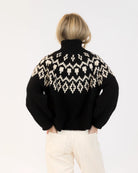 Woman wearing a fairisle sweater in blavk with cream accents