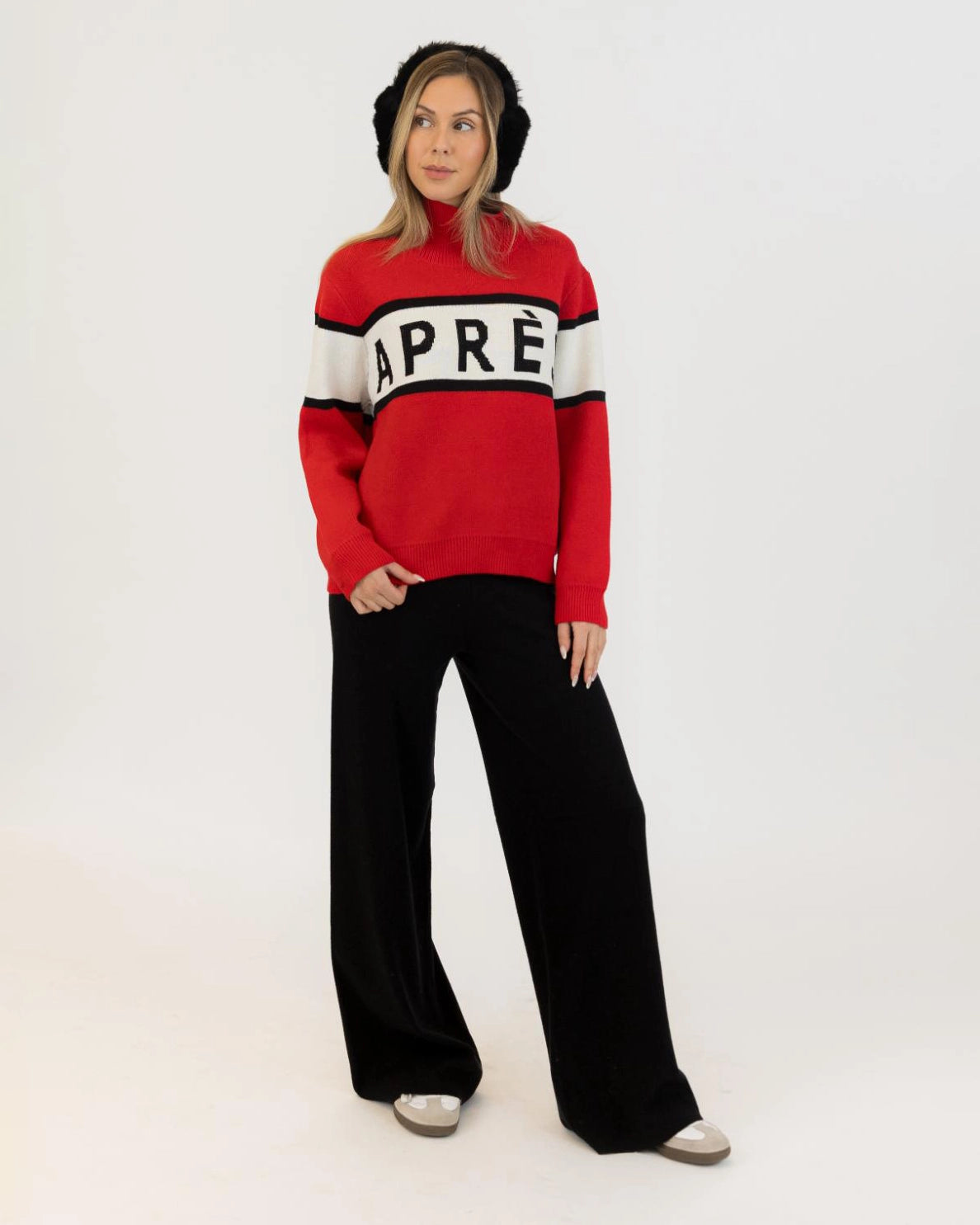 Woman wearing a red sweater with black and white accents with 'Après' on it