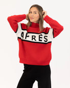 Woman wearing a red sweater with black and white accents with 'Après' on it