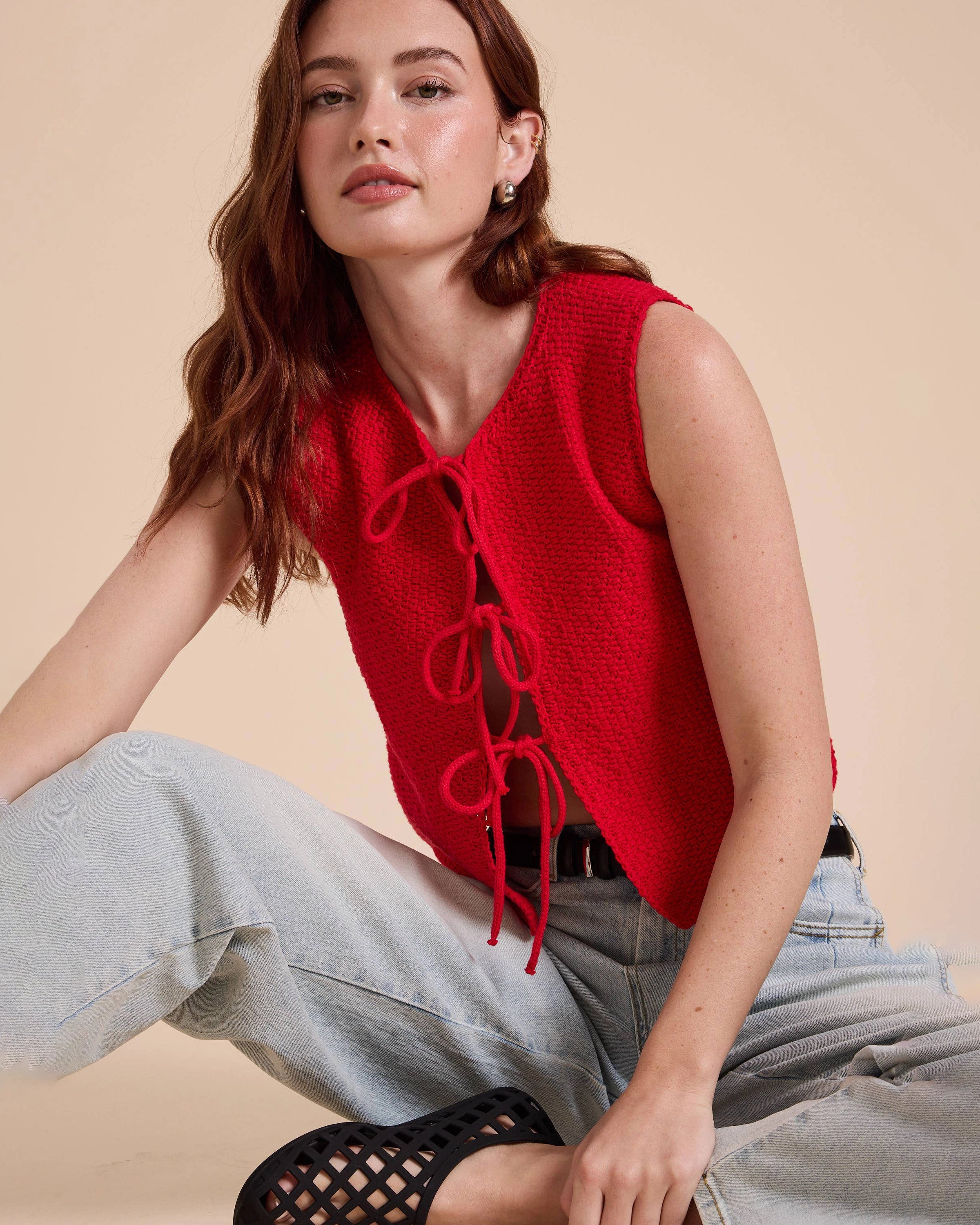 Woman wearing a red sleeveless top with lace-up front