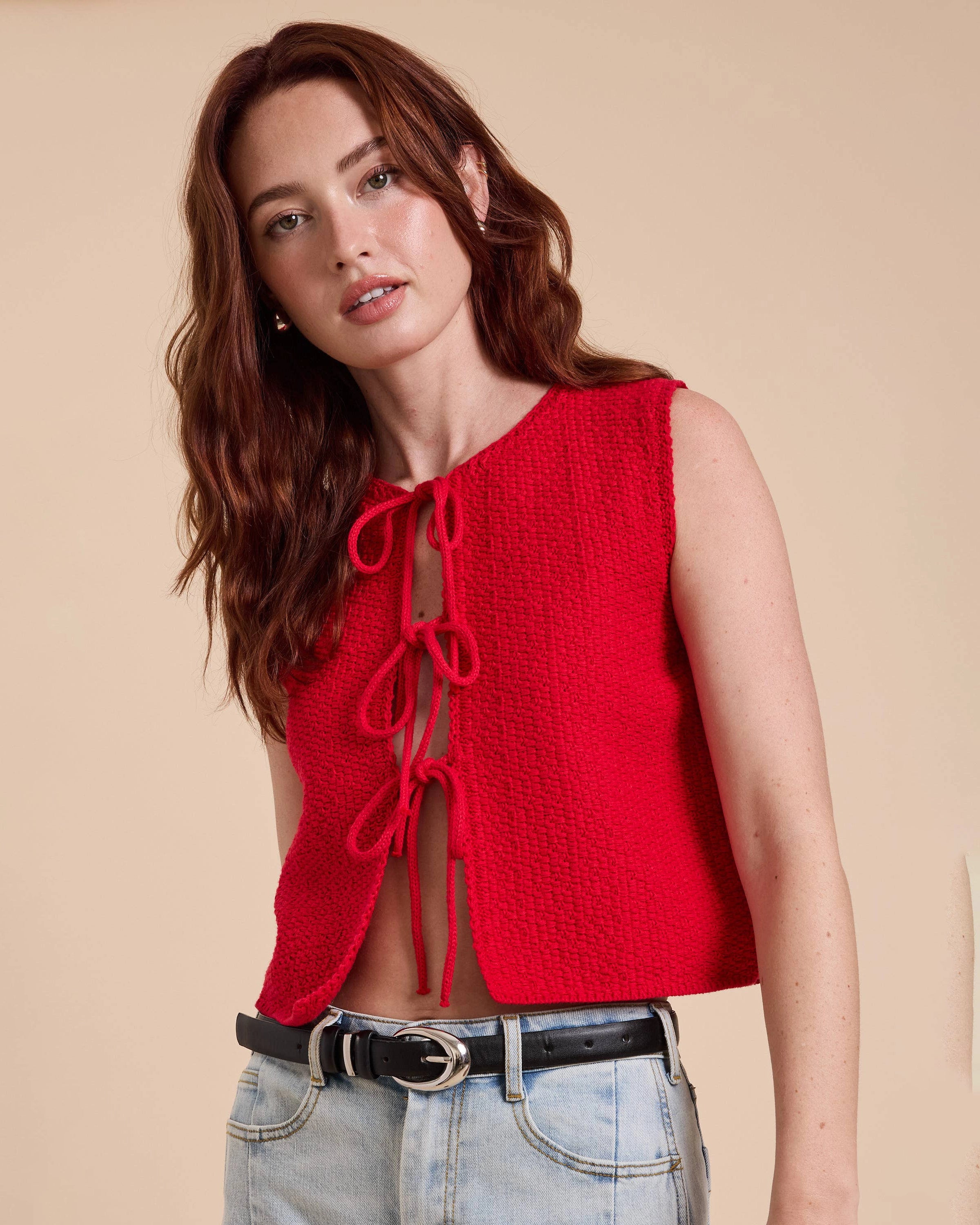 Woman wearing a red sleeveless top with lace-up front