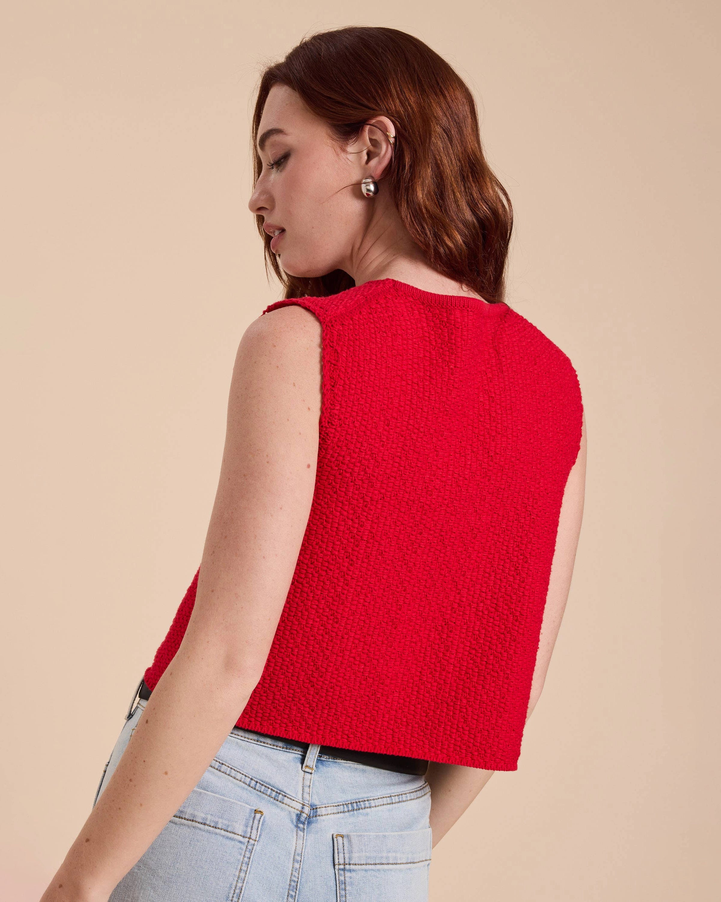 Woman wearing a red sleeveless top with lace-up front