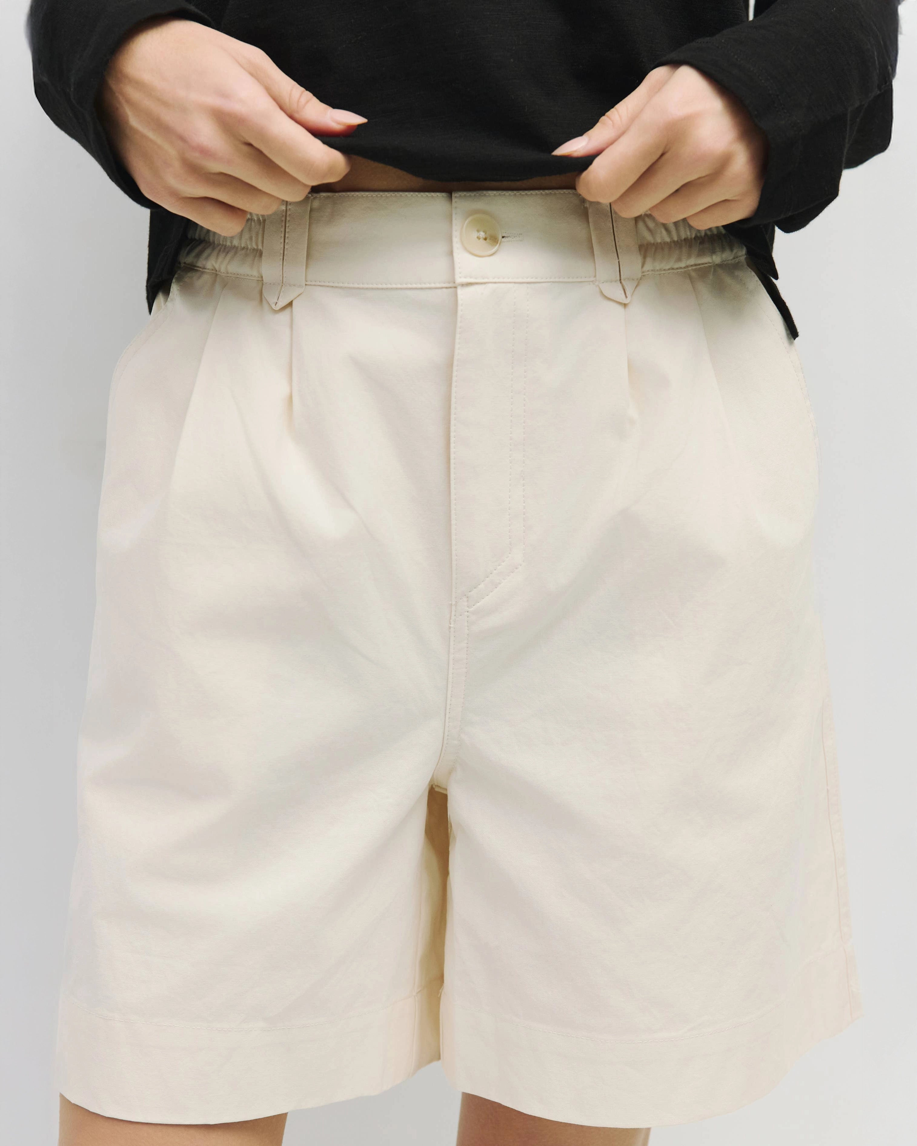 woman wearing white wide leg chino shorts