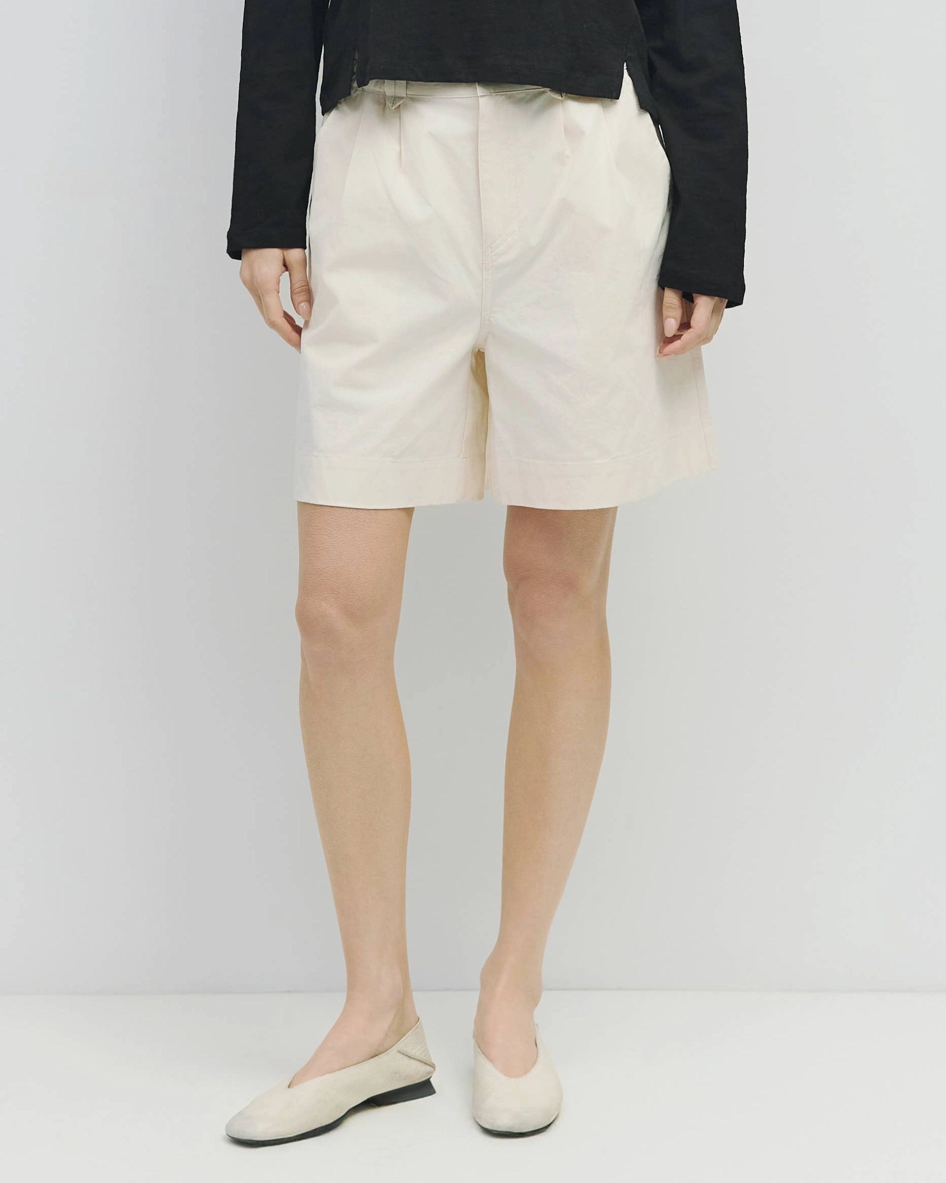 woman wearing white wide leg chino shorts