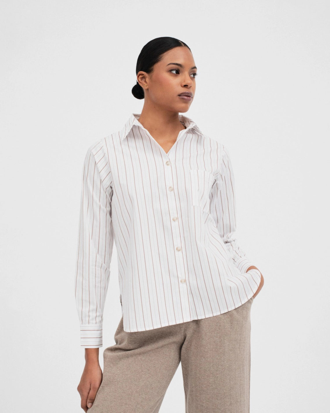 woman wearing a button up cotton shirt in white with brown stripes