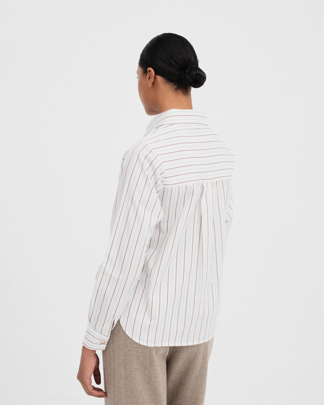 woman wearing a button up cotton shirt in white with brown stripes