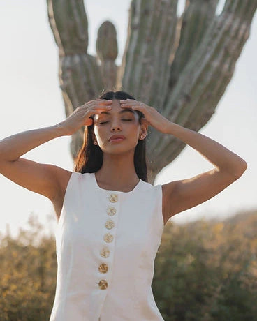 a woman wears a white button down vest with large vintage statement buttons