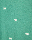 green fabric with white bears embroidered all over