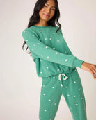Woman wearing a green pajama set with white bears embroidered all over