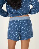 A woman wearing blue polka dot floral shorts