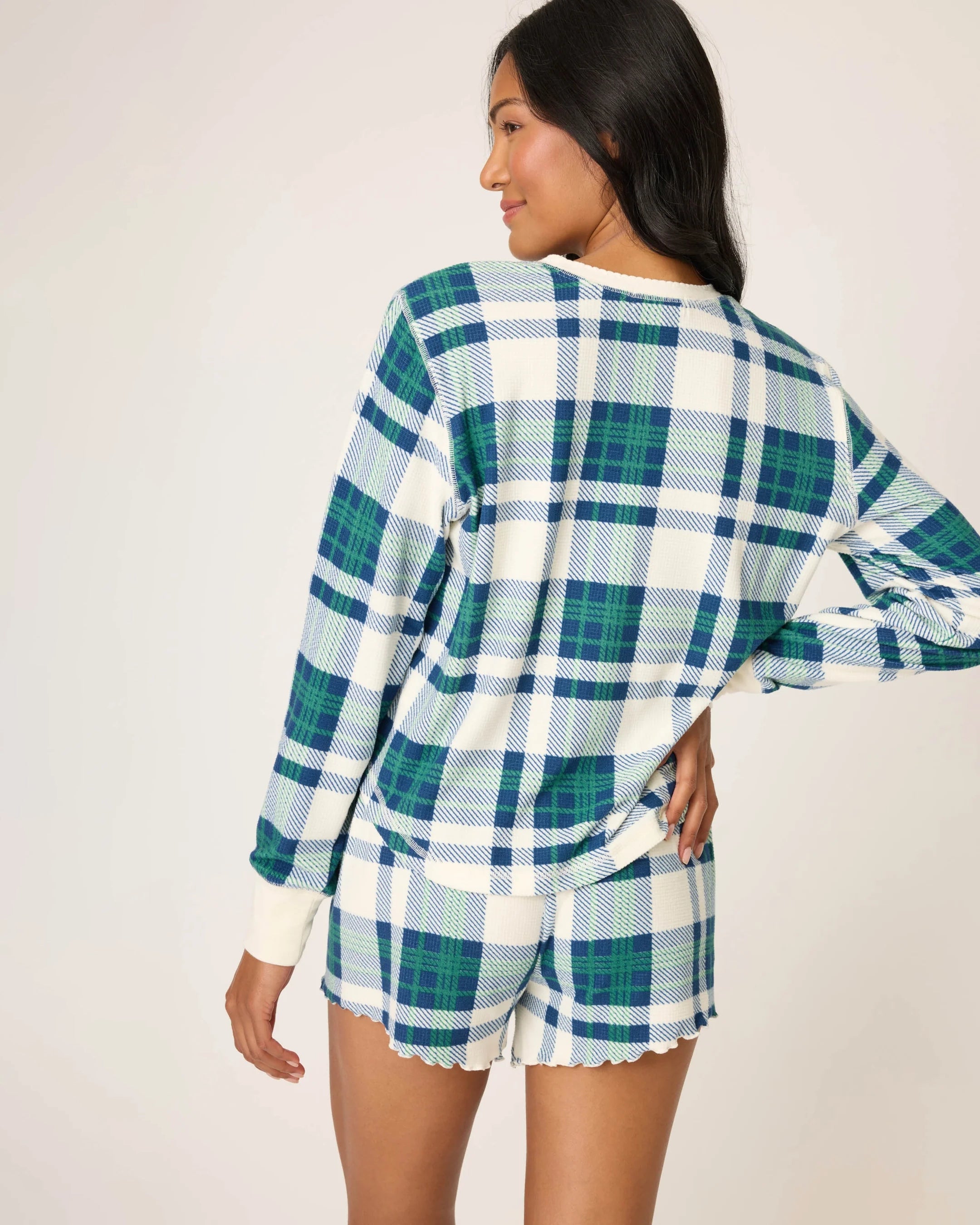 Woman wearing a blue, green and white plaid pyjama set