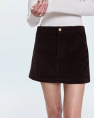 A woman wearing a brown corduroy skirt