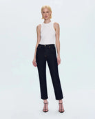 a woman wearing cropped dark wash ankle denim jeans by Pistola