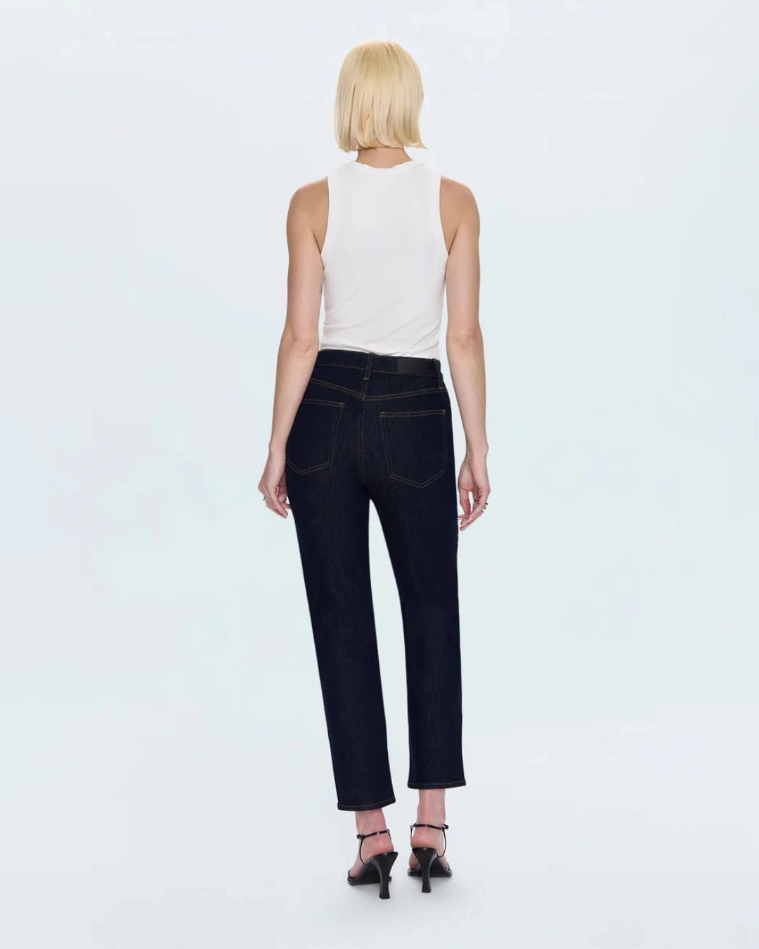 a woman wearing cropped dark wash ankle denim jeans by Pistola