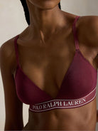 a model wears a branded triangle bralette by polo ralph lauren in a dark burgundy colour