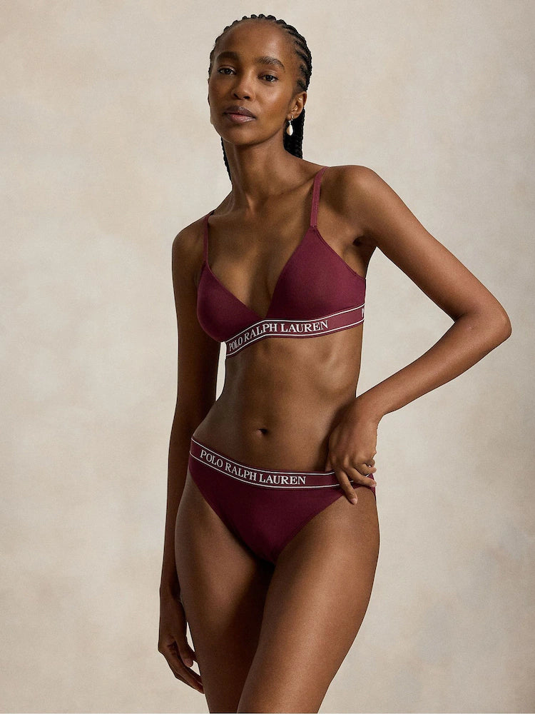 a model wears a branded triangle bralette by polo ralph lauren in a dark burgundy colour