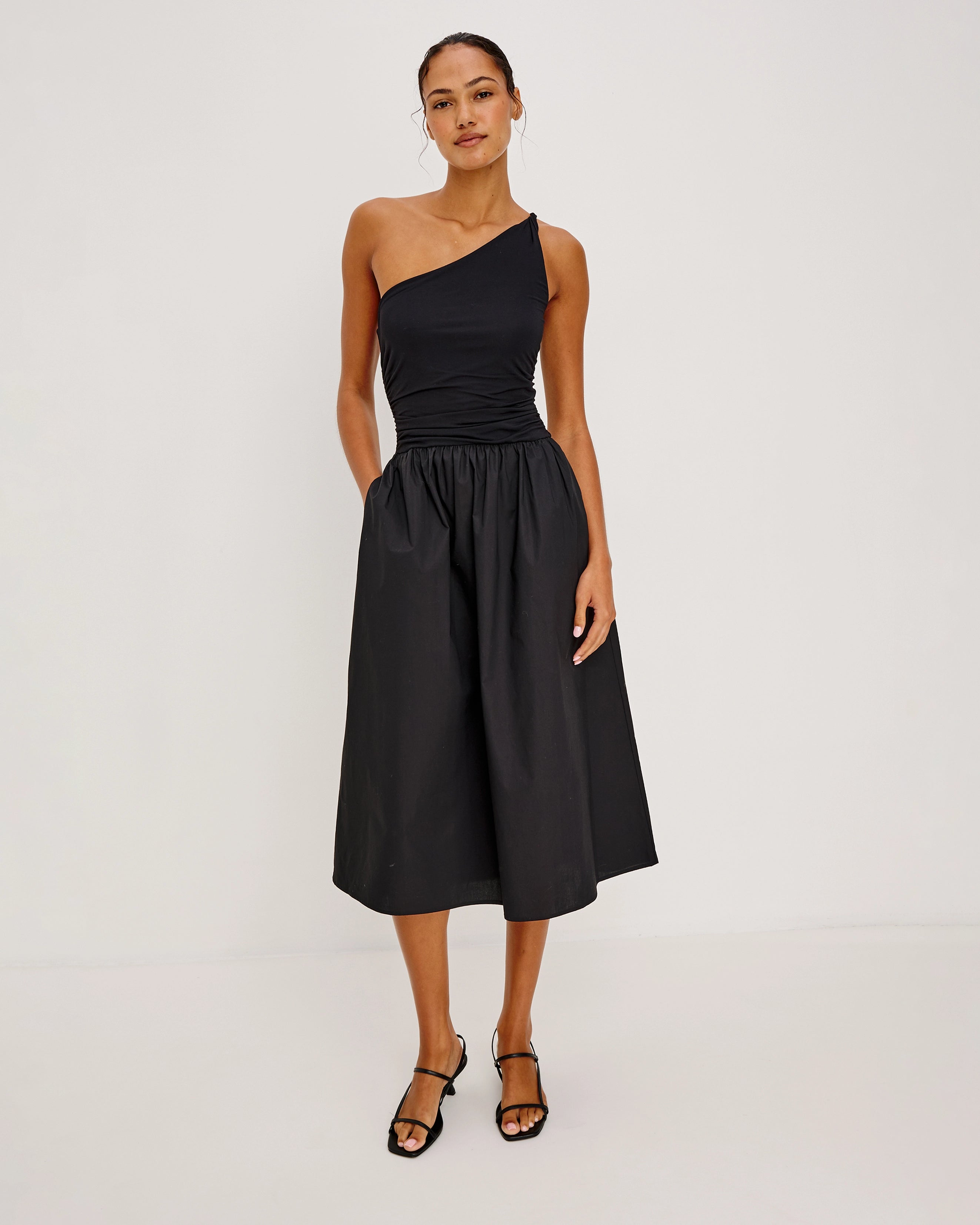 a woman wears an asymmetrical one shoulder dress in black