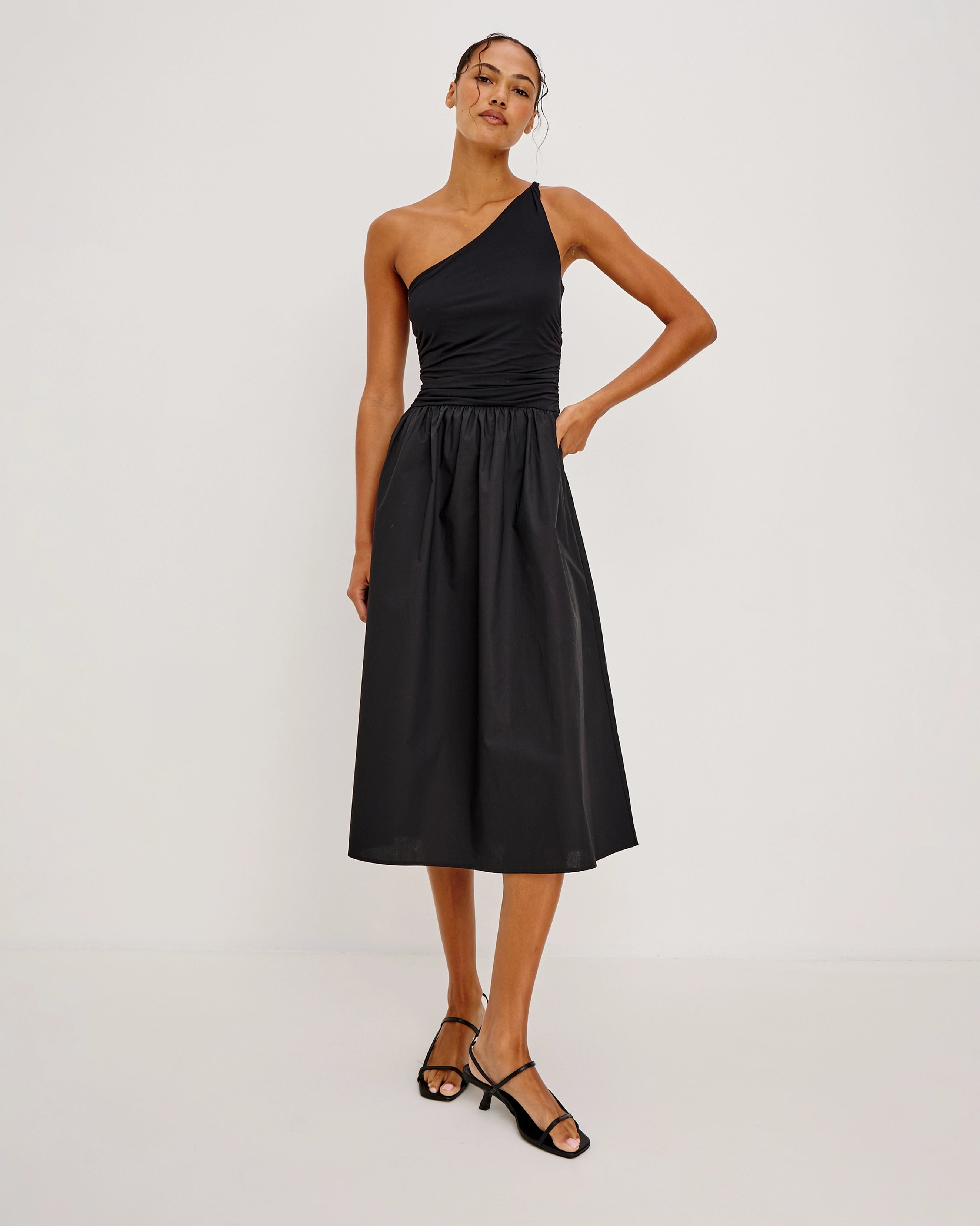 a woman wears an asymmetrical one shoulder dress in black