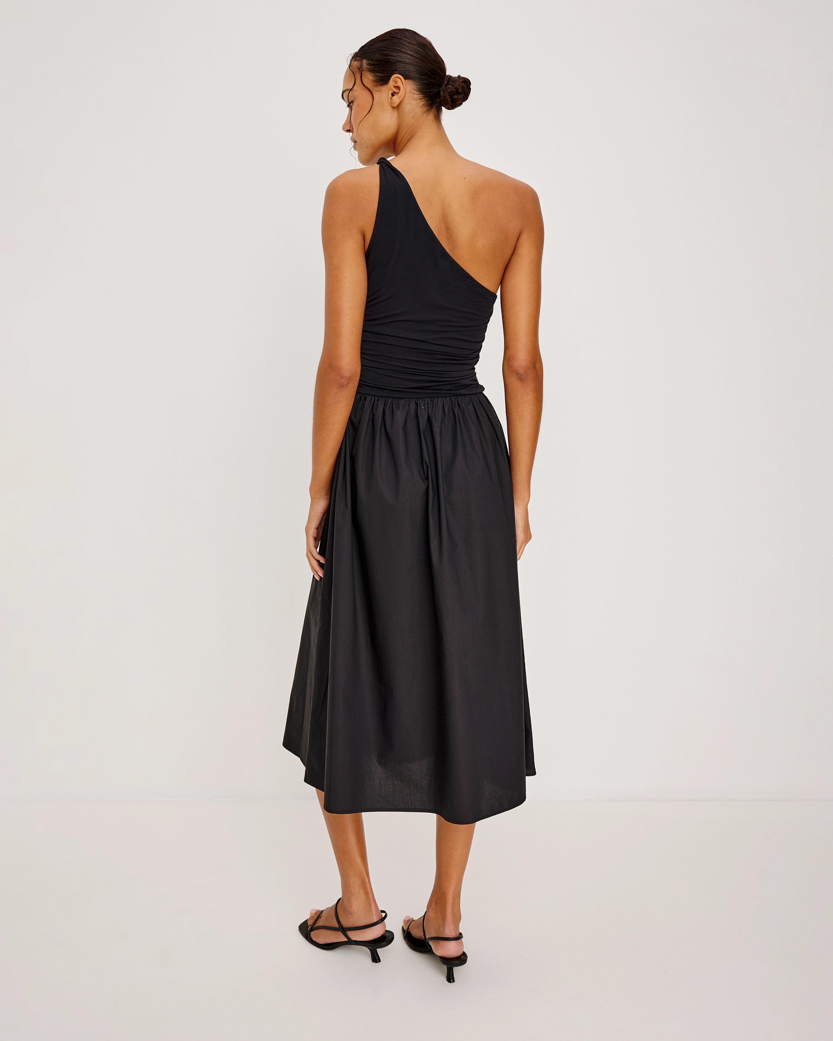 a woman wears an asymmetrical one shoulder dress in black