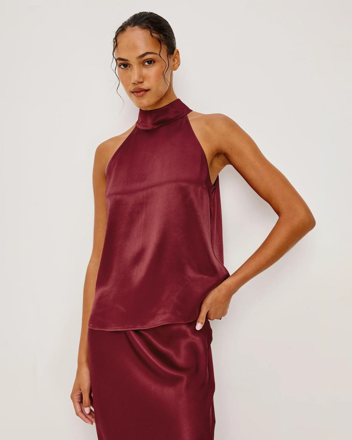 Woman wearing a burgundy satin halter top