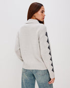 Grey zip up sweater with two skiiers on the chest in blue