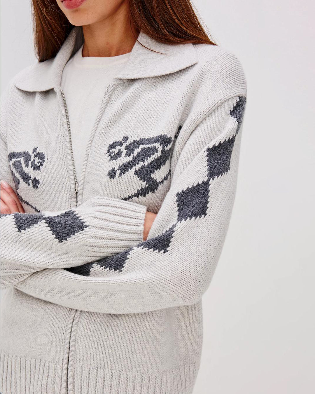 Grey zip up sweater with two skiiers on the chest in blue