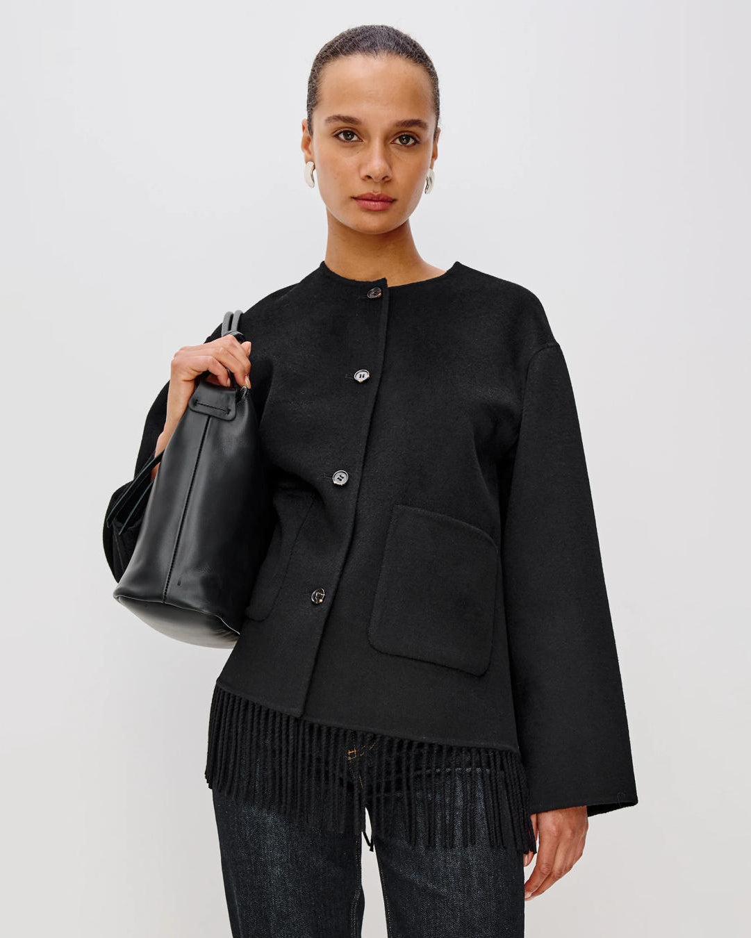 Person wearing a black jacket with fringes  on the hem