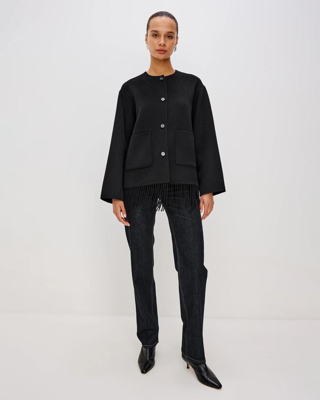 Person wearing a black jacket with fringes  on the hem