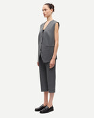 woman wearing a grey pinstriped vest 
