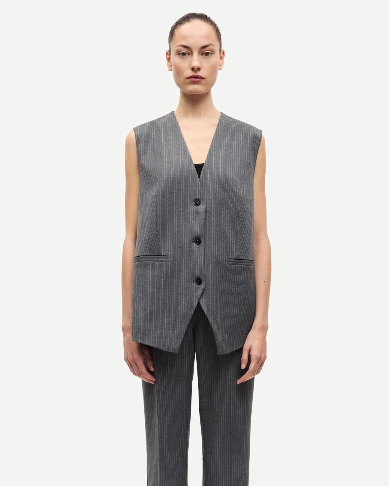 woman wearing a grey pinstriped vest 