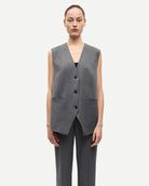 woman wearing a grey pinstriped vest 