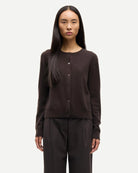 Woman wearing a brown button-up cashmere cardigan by Samsoe Samsoe
