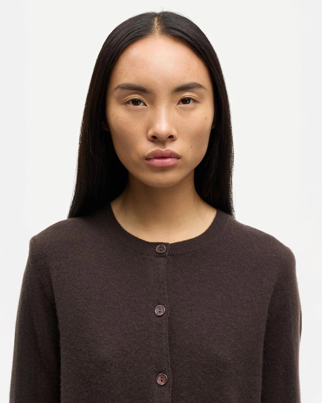 Woman wearing a brown button-up cashmere cardigan by Samsoe Samsoe