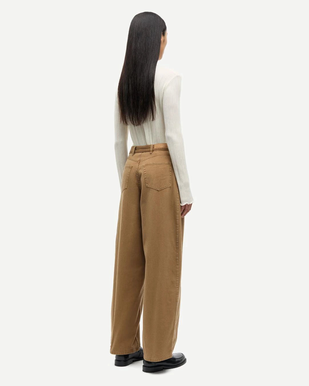 a woman wearing 100% cotton jeans with belt in khaki colour