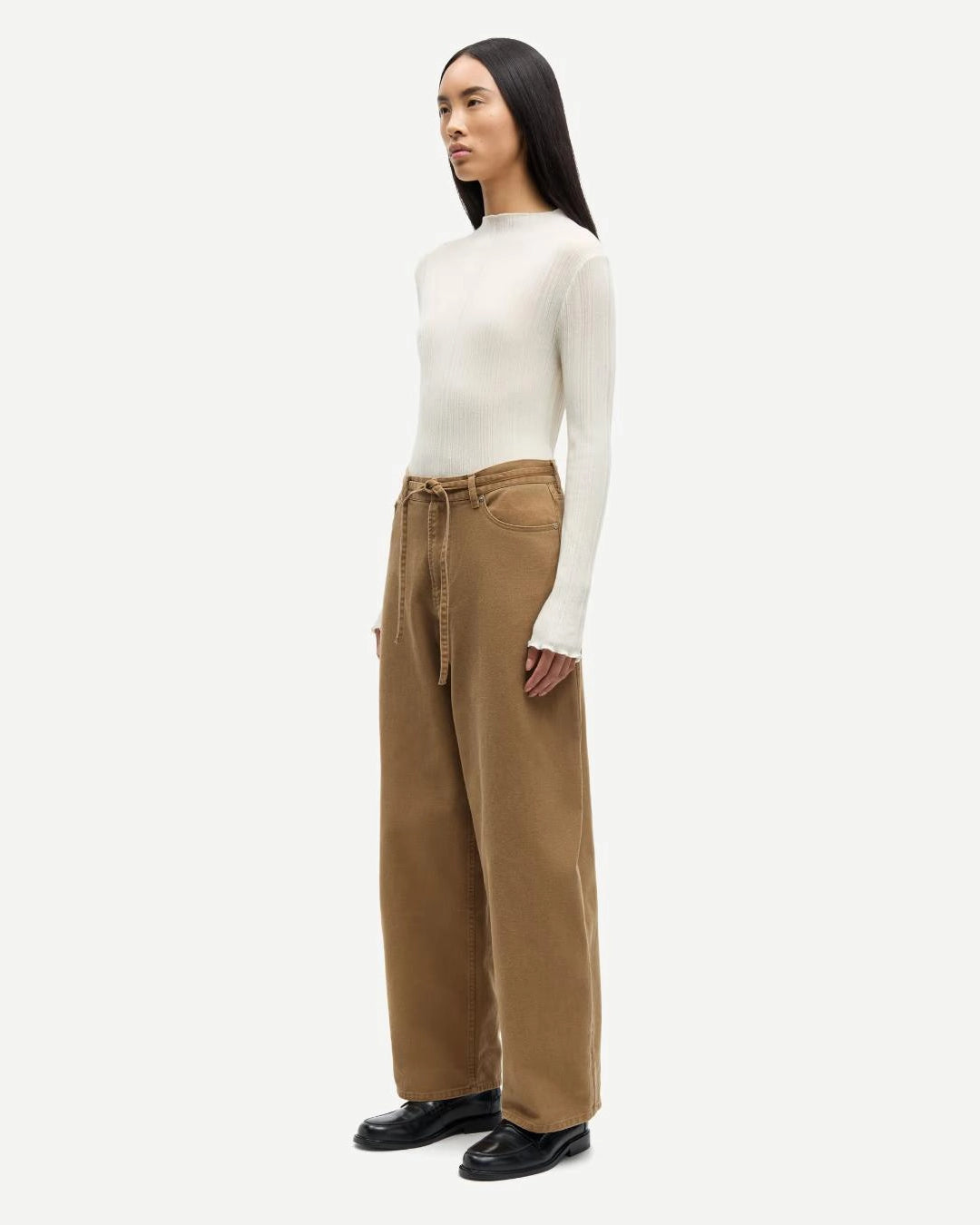 a woman wearing 100% cotton jeans with belt in khaki colour
