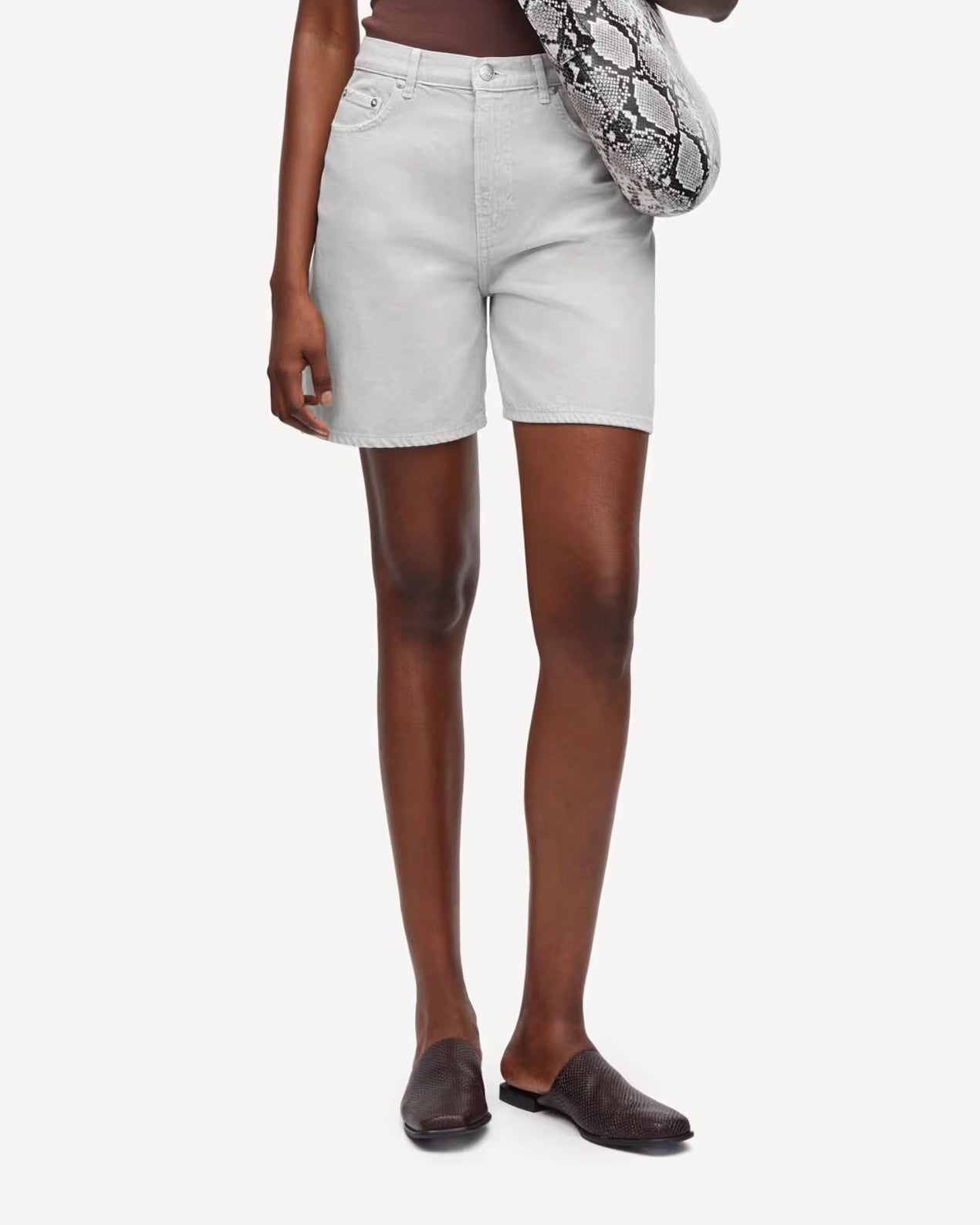 Person wearing white denim shorts