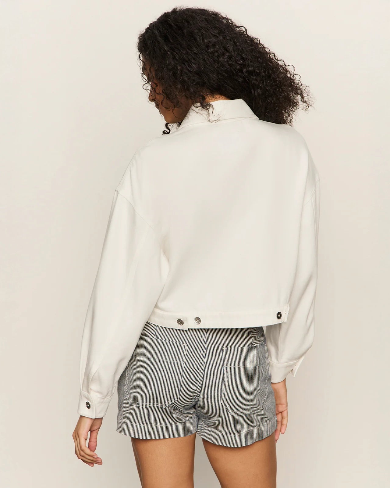 Woman wearing a white cropped zip jacket