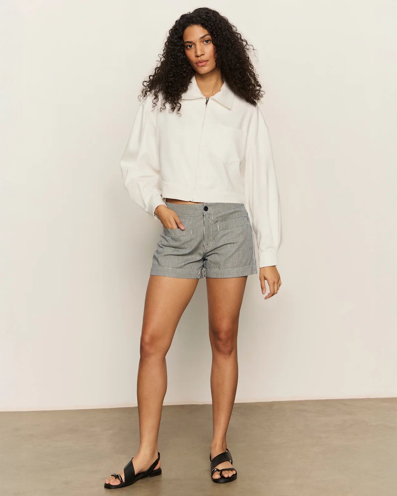 Woman wearing a white cropped zip jacket