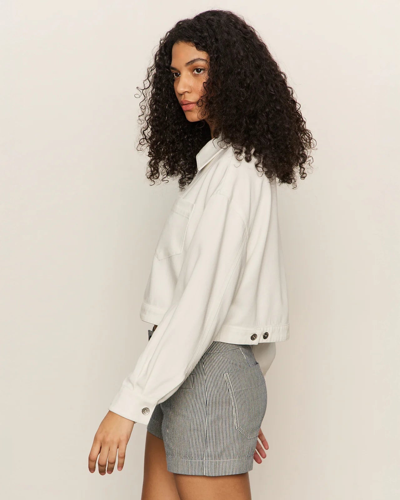 Woman wearing a white cropped zip jacket